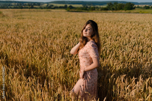 A woman in a beautiful dress in a rye field in the morning