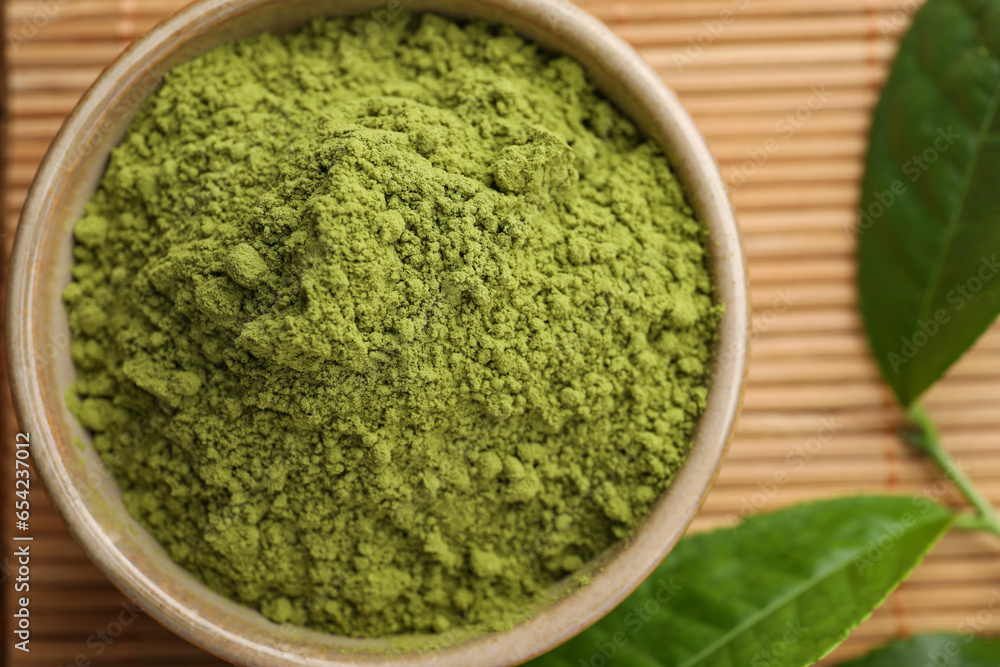 Bowl of green matcha powder on bamboo mat, top view Bowl of green matcha powder on bamboo mat, top view