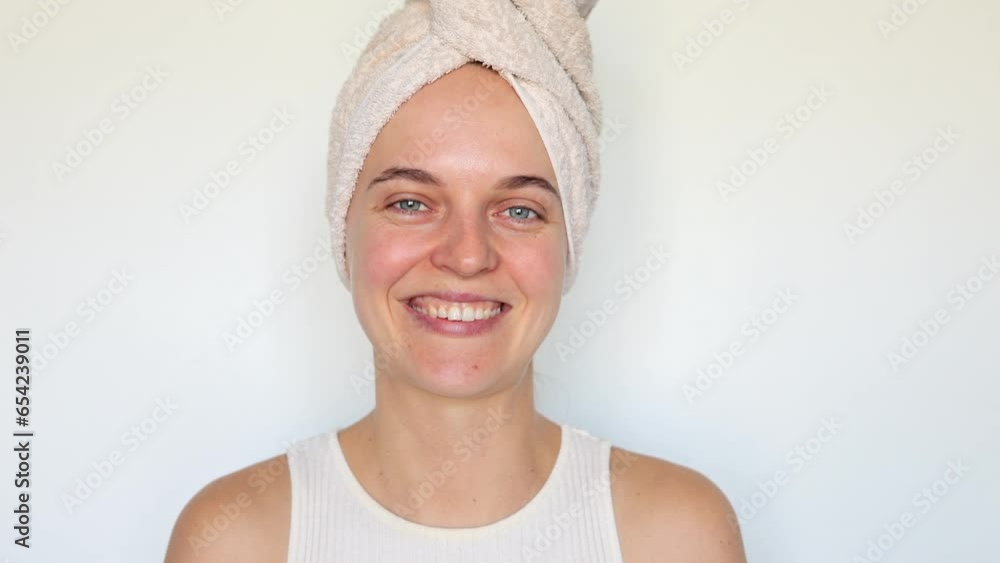 Cheerful romantic woman wearing bath towel on head isolated over white background sending air kiss over palms flirting while doing beauty procedures after taking morning shower. Cheerful romantic woman wearing bath towel on head isolated over white background sending air kiss over palms flirting while doing beauty procedures after taking morning shower.
