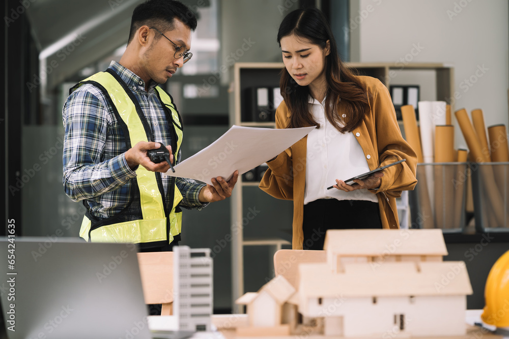 Businessman working as a team discussing data working and tablet, laptop with on on architectural project at construction site at desk in office. Businessman working as a team discussing data working and tablet, laptop with on on architectural project at construction site at desk in office.