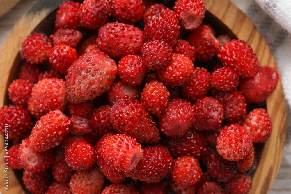 Fresh wild strawberries in bowl on table, top view Fresh wild strawberries in bowl on table, top view