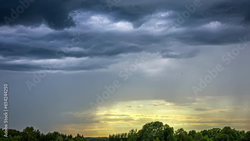 Dramatic Clouds Drift Overhead with Sunlight Below in a Motion Timelapse in Latvia. photo