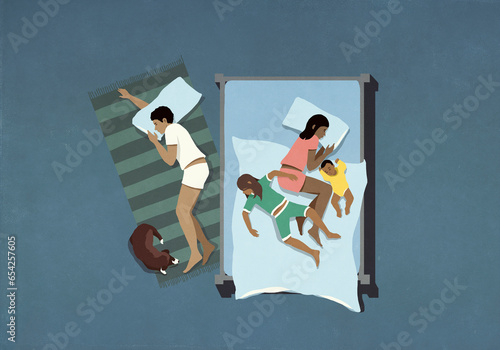 Man and dog sleeping on floor below wife and kids sleeping in bed
