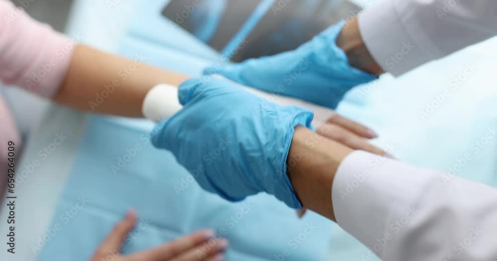 Traumatologist bandages patient sore arm. Hand injuries and sprains concept Traumatologist bandages patient sore arm. Hand injuries and sprains concept