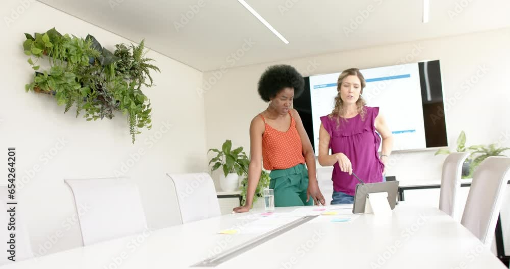 Diverse female creative colleagues brainstorming in meeting in board room, slow motion Diverse female creative colleagues brainstorming in meeting in board room, slow motion