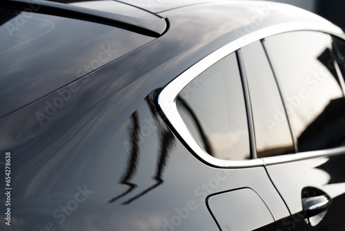 Close up of prestigious modern vehicle with tinted windows, chrome details and black surface. Beautiful exterior of new car