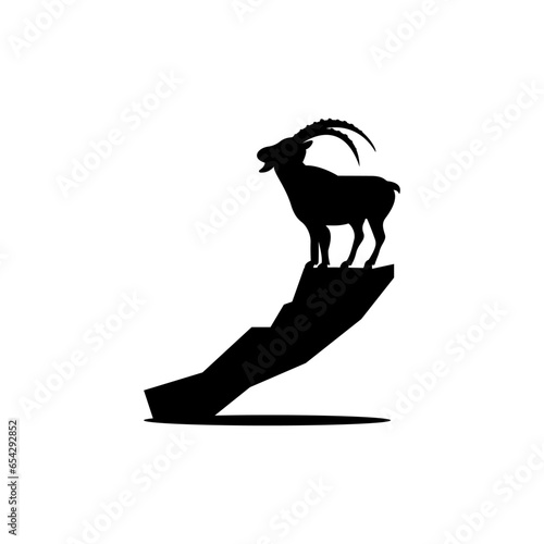Black silhouette of a mountain goat on a rock.