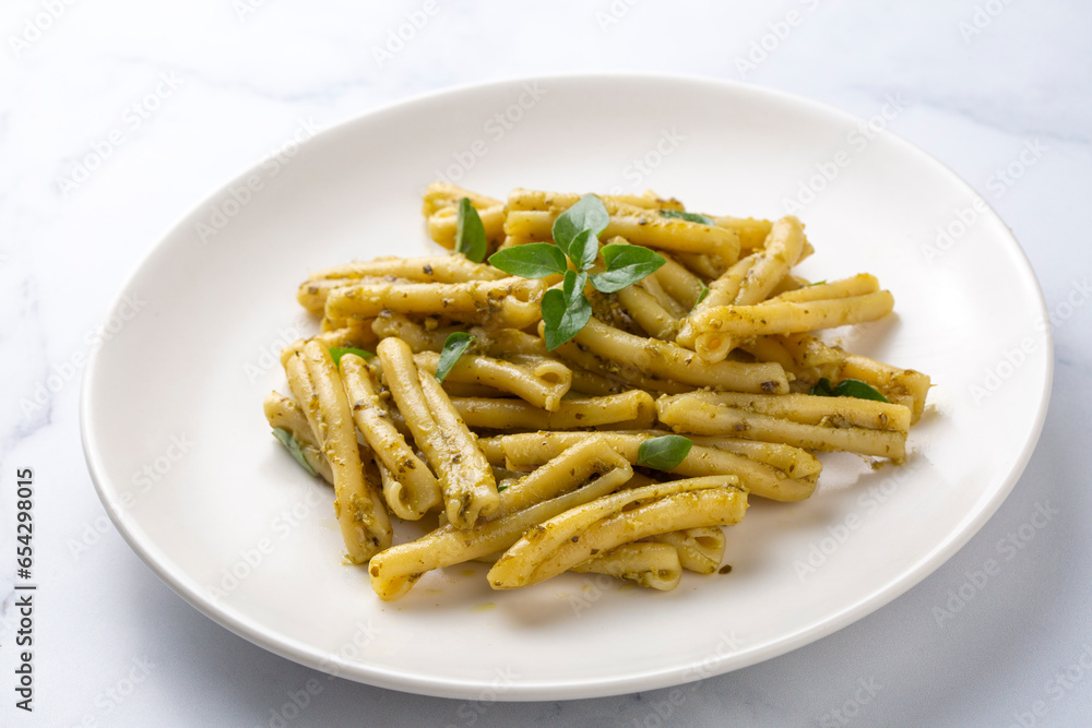 Casarecce pasta with cilantro pesto sauce on a grey background, top view. Delicious vegetarian lunch. Casarecce pasta with cilantro pesto sauce on a grey background, top view. Delicious vegetarian lunch.