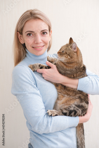 Canvas Print A pretty young woman is holding her cat.