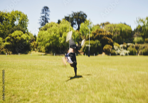Cheerleader, blur and cartwheel on field for performance, dance and training outdoor. Cheerleading, moving and energy for workout, motion and fast at event for sport competition, game and acrobat