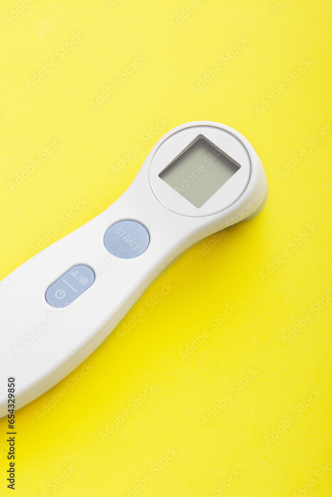 Electronic thermometer on a yellow background Electronic thermometer on a yellow background