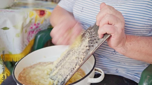 a woman grates potatoes. cooking food