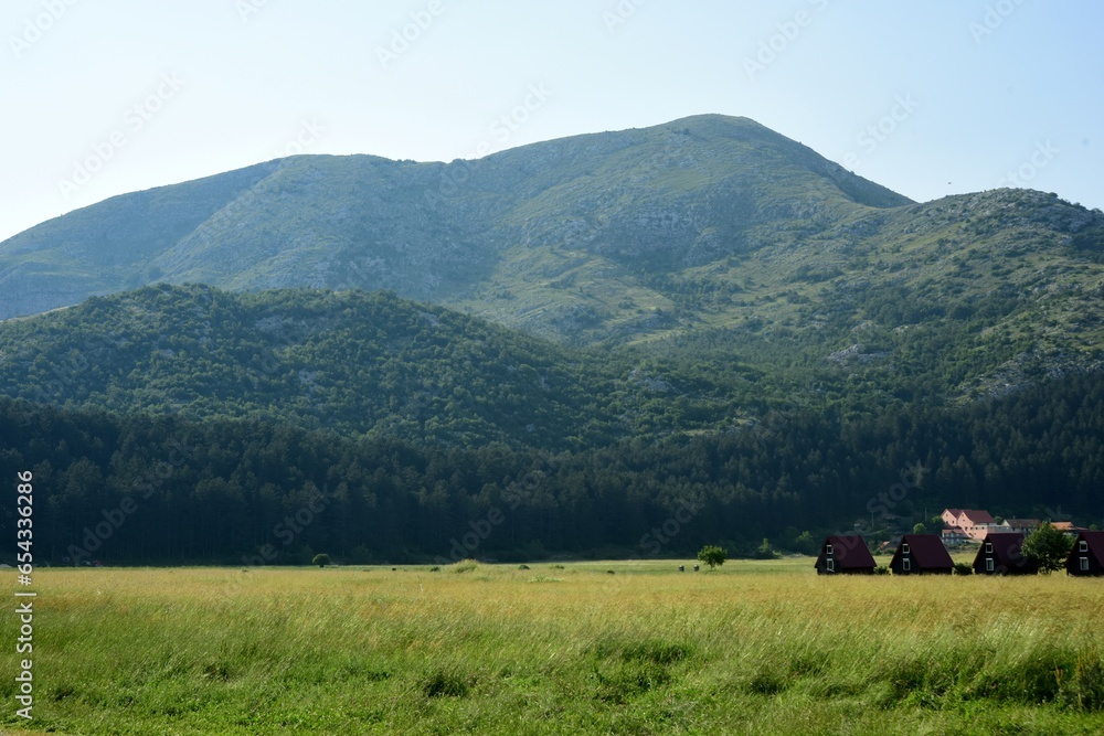 Montenegro LANDSCAPE WITH WOODEN TOURIST HOUSES ON THE BACKGROUND OF MOUNTAINS, CAMPING, HOTEL