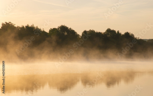 Landscape with fog on the lake in the morning at sunrise