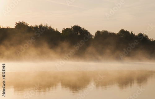 Steam evaporating from the lake in the morning at sunrise