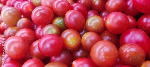 Tomatoes lying on a pile on top of each other, tomato texture. Selective focus.