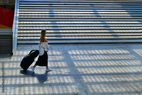 Unrecognizable silhouette of lonely young female beauty walking at station with backpack