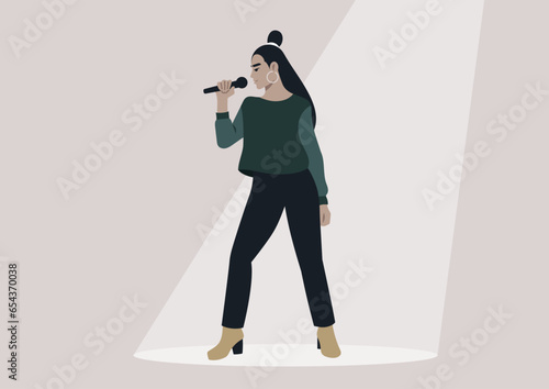 A youthful, self-assured singer on a well-lit stage, holding a microphone beneath the spotlight