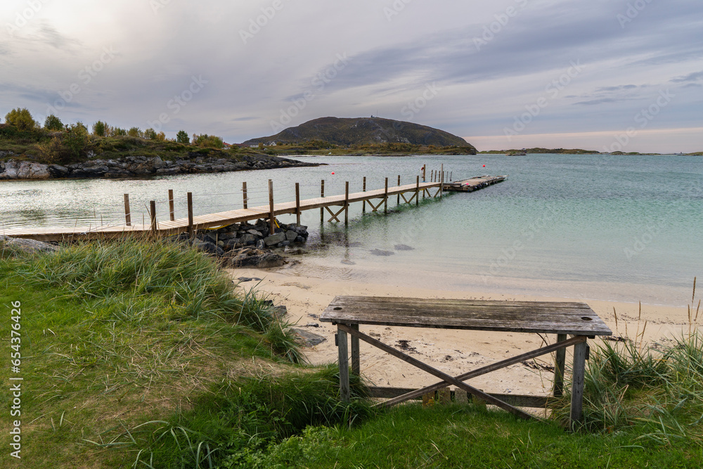 Bootssteg am Atlantik in Sommarøy, Troms, Norwegen. Dock beim Campingplatz mit Grillplatz und Spielwiese. Insel mit Berg im Hintergrund, türkis blaues Wasser wie in der Karibik, Bootssteg am Atlantik in Sommarøy, Troms, Norwegen. Dock beim Campingplatz mit Grillplatz und Spielwiese. Insel mit Berg im Hintergrund, türkis blaues Wasser wie in der Karibik,