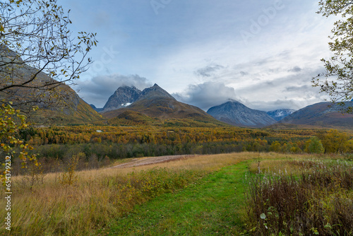 Fototapeta Naklejka Na Ścianę i Meble -  steile Berge in den Lyngenalps von Troms in Norwegen. tiefe Gletschertäler mit herbstlich gefärbten Bäumen und felsigen Gipfeln im Herbst. wunderbare stille Natur, in der man sich erholen kann