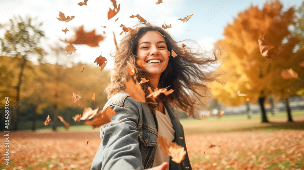 Woman drop leaves in autumn park. Beautiful joyful woman enjoy, having fun at the autumn season at park. Fall season fashion.

 - obrazy, fototapety, plakaty 