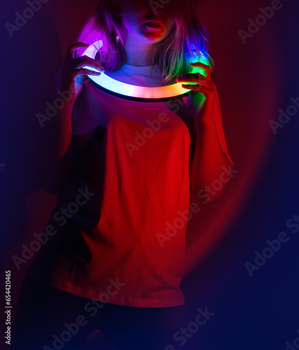 Woman dance on the stage in neon lighting. Model in vibrant neon fantastic glowing dance during performs on stage.