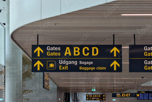 airport terminal sign (gate a b c d exist) english and danish in Copenhagen (modern, directional) white ceiling