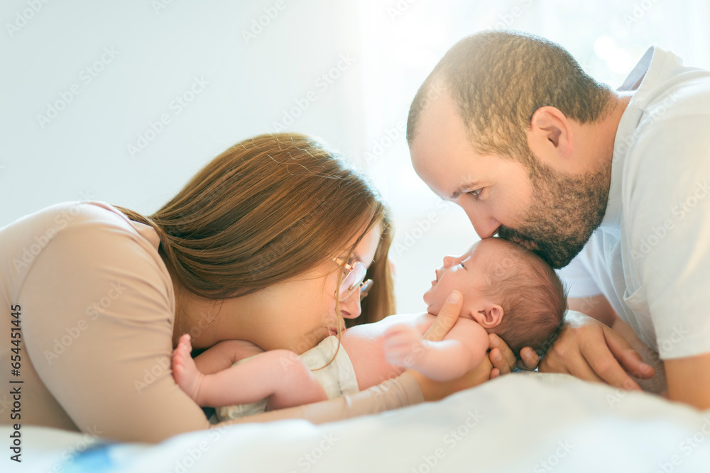 father and mother on bedroom with his newborn baby son father and mother on bedroom with his newborn baby son