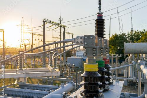 Insulators and transformers at an electrical substation. electrical equipment at sunset in the rays of the setting sun.