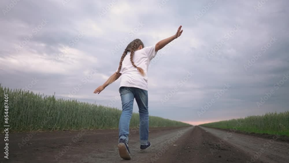 girl child running in nature in the park. happy family kid dream concept. free child daughter runs along a rural road next to a field in nature. free girl runs and plays in the park lifestyle girl child running in nature in the park. happy family kid dream concept. free child daughter runs along a rural road next to a field in nature. free girl runs and plays in the park lifestyle