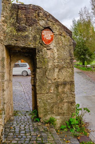 old stone wall with red sign on it 