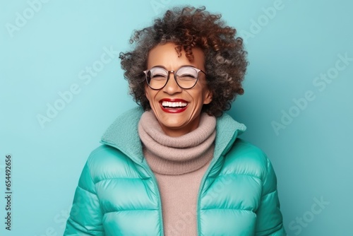 Senior afroamerican woman in warm winter outfit over blue background. Healthy, happy aged lady © netrun78