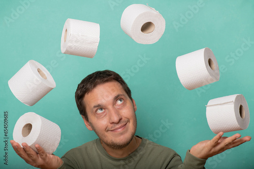 Fotografía A thrifty and greedy man juggles rolls of toilet paper.