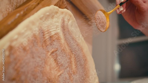 A girl sprinkles cinnamon sugar on the dough for her cinnabons. A man prepares the dough. High quality 4k footage