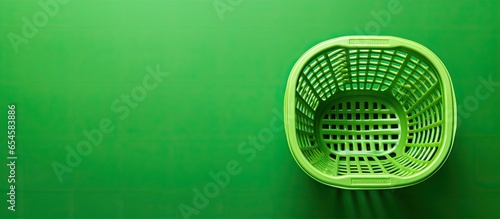 Black Friday sale concept with shopping basket on green background featuring copy space and sustainable lifestyle © TheWaterMeloonProjec