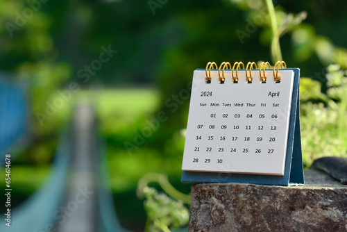 April 2024 calendar with green blurred background of hanging bridge.