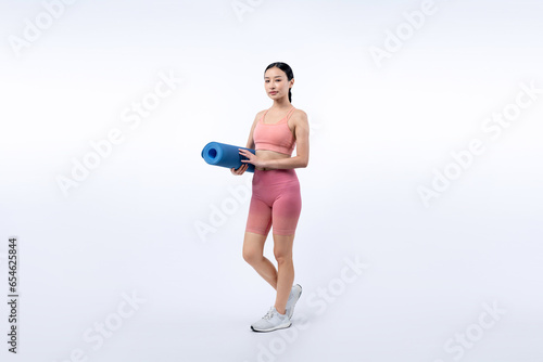 Young attractive asian woman portrait in sportswear with exercising mat. Healthy exercise and workout routine lifestyle concept. Studio shot isolated background. Vigorous