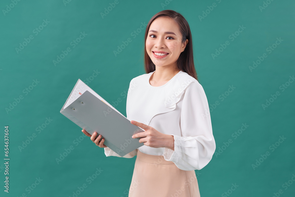 Beautiful business woman taking notes on her clipboard isolated on green background Beautiful business woman taking notes on her clipboard isolated on green background