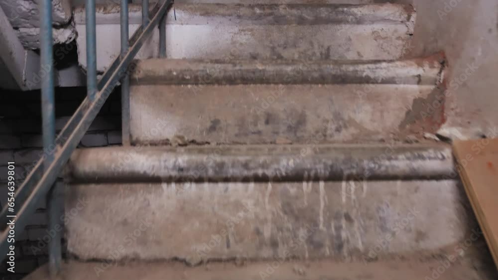 Slowly he climbs the narrow concrete stairs in the abandoned building. POV view from a personal perspective. Steps in paint drips, chunks of plaster and dust. Slow motion Slowly he climbs the narrow concrete stairs in the abandoned building. POV view from a personal perspective. Steps in paint drips, chunks of plaster and dust. Slow motion