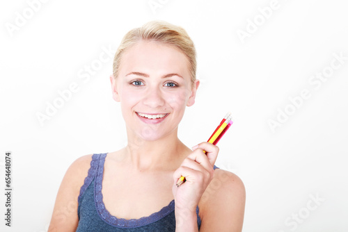 portrait of blonde model holding up colourful pencils