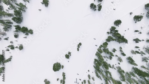 Top down view on ski elevators on snow mountain landscape at overcast moody day. Winter activity in Sierra Nevada, California, USA 4K. People skiing and snowboarding on snow slope Mammoth lakes resort