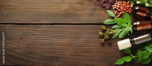 Top view of bottles and pills made from healing herbs on wooden background promoting homeopathy