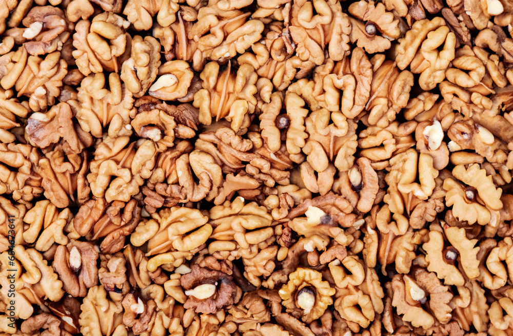 Fototapeta premium Halves of walnut kernels form the background.