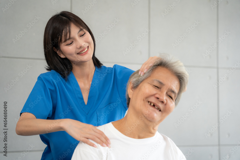 Fototapeta premium Senior woman being massage by nurse at hospital. She feeling happy and relax with massaging and sitting on wheelchair at hospital.