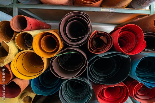 Colorful raw genuine vegetable tanned leather on shelf in crafts shop photo