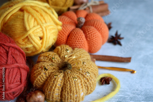 Cozy autumn crochet. Close up photo of handmade amigurumi toys made of natural yarn. Cute decorations for autumn holidays. Hobbies and leisure concept. 