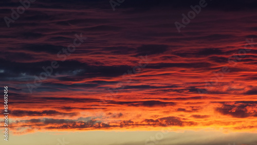 Ciel rougeoyant pendant un coucher de soleil, derrière des nuages de haute altitude