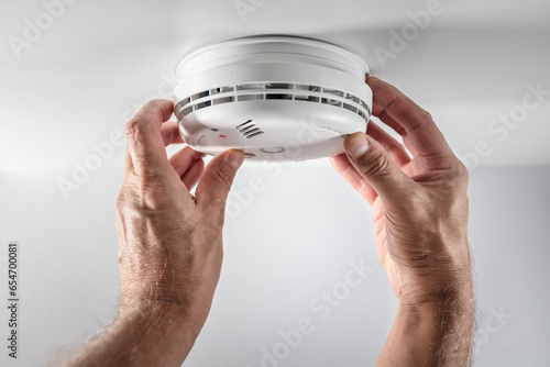 Home smoke and fire alarm detector installing, checking, testing or replace battery photo