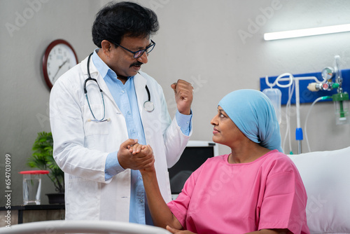 Indian senior doctor consoling or encouraging woman cancer patient by giving confidence at hospital - concept of Emotional Support, Medical Empathy and Empathy.