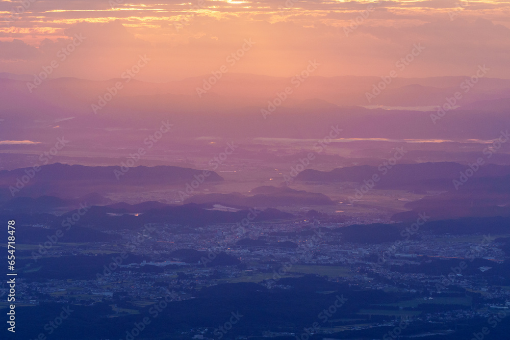 夜明けの朝日の光が降り注ぐ田舎の町と山々　栃木県那須
